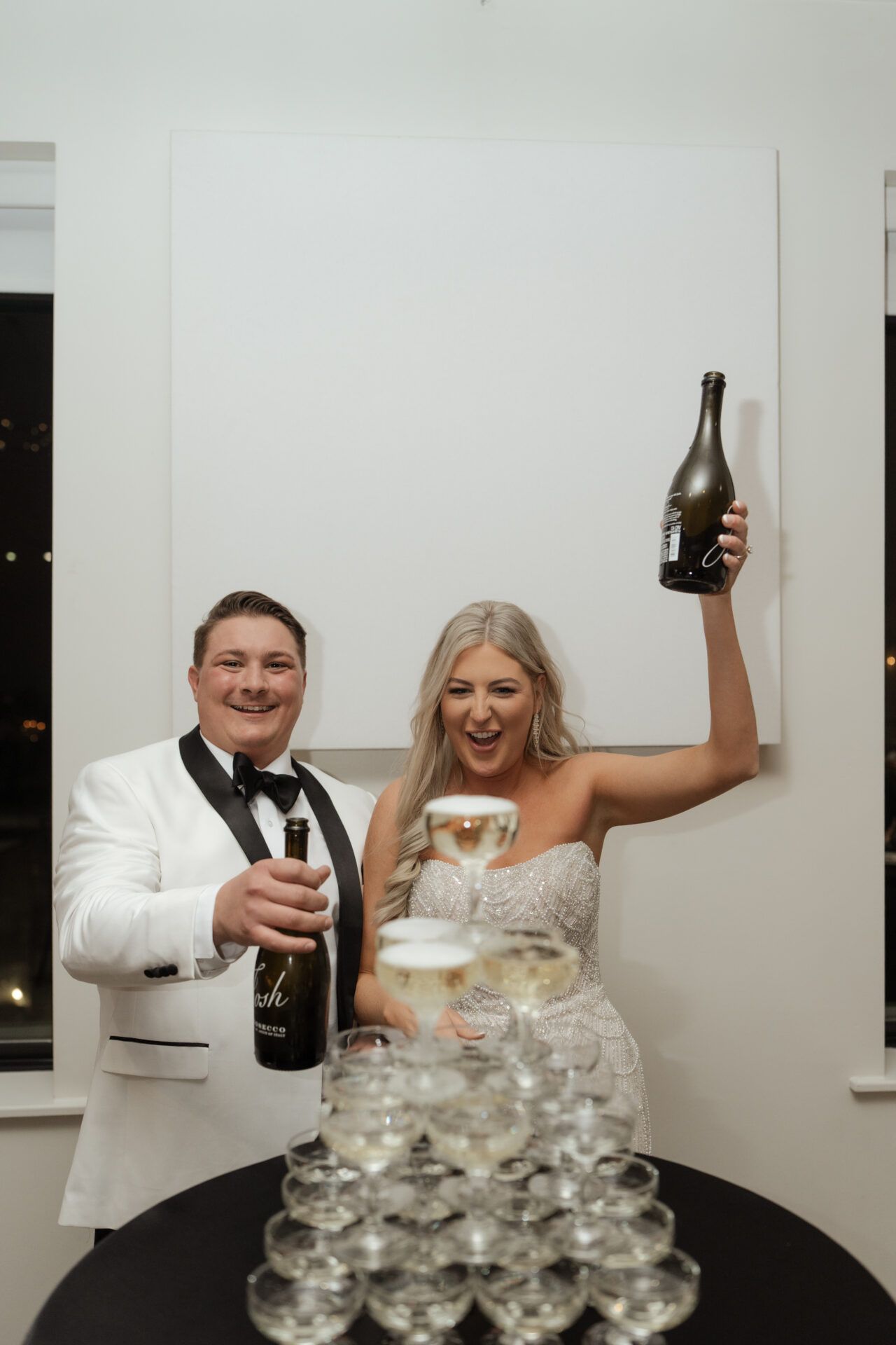 bride and groom with champagne tower during wedding reception