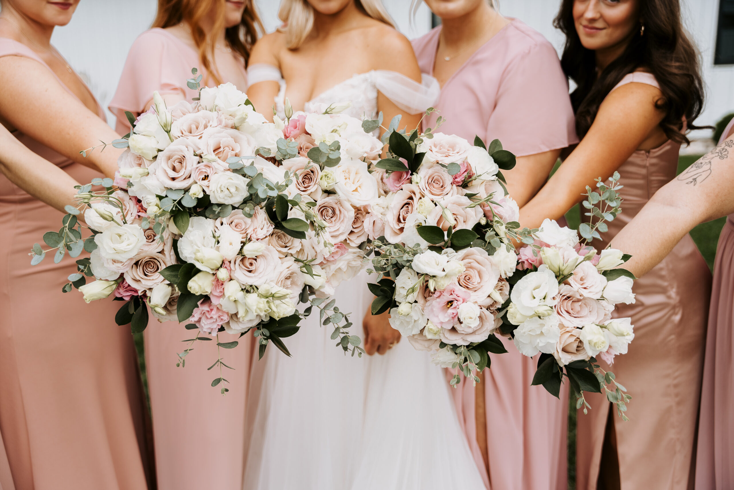 pink, white, and green wedding flower bouquets with light pink bridesmaid dresses in summer
