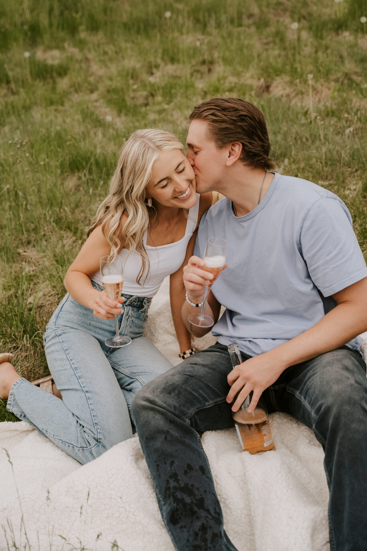 couple enjoying a picnic together during engagement photos in the summer