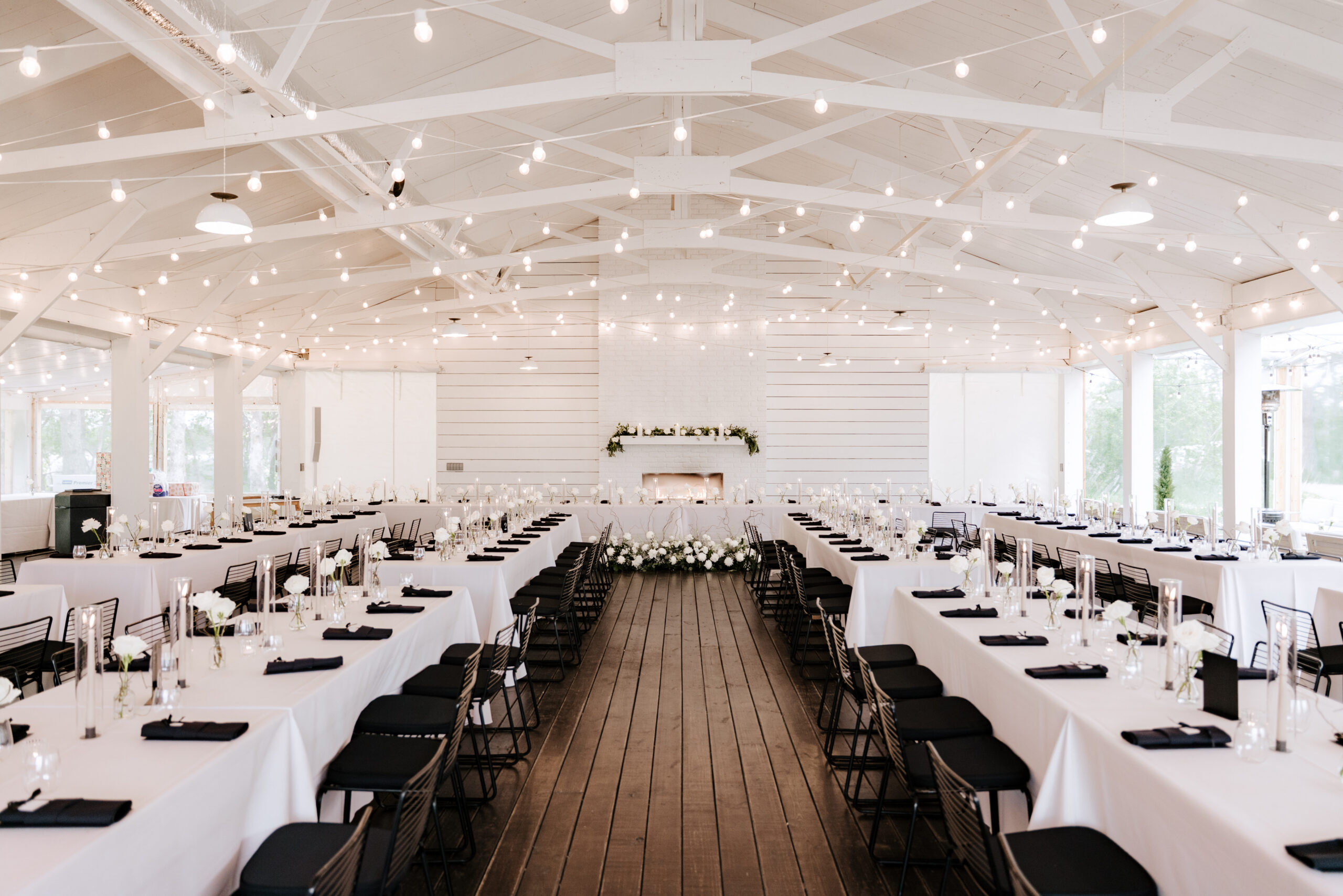 ivory north co reception area with string lights and white table linens with white florals