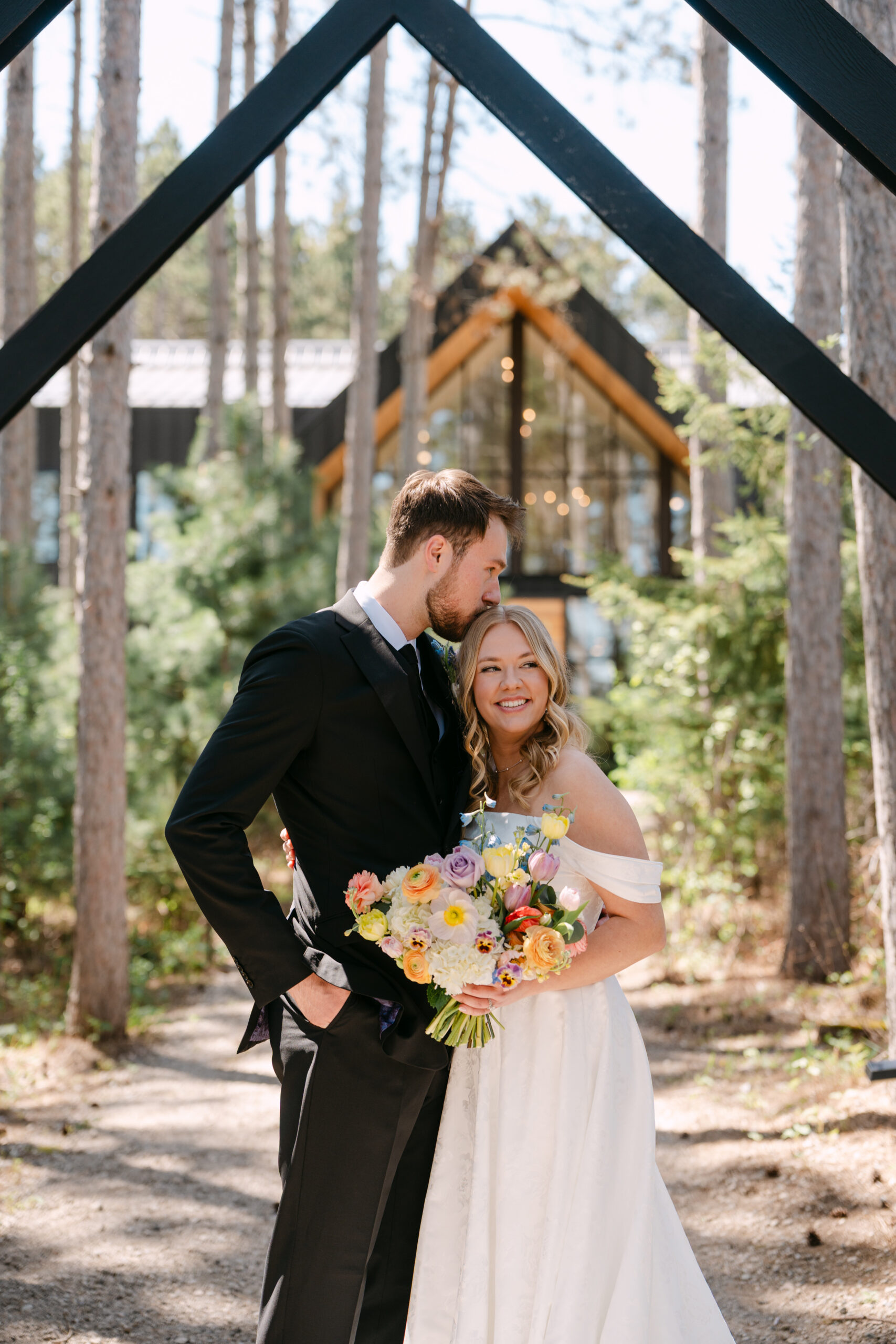 bride and groom in front of modern pinewood wedding venue
